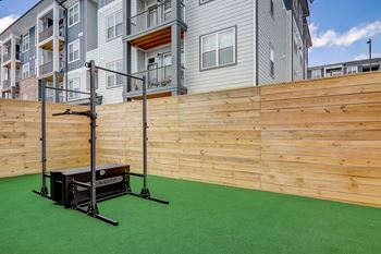 a backyard with synthetic grass and a wood fence
